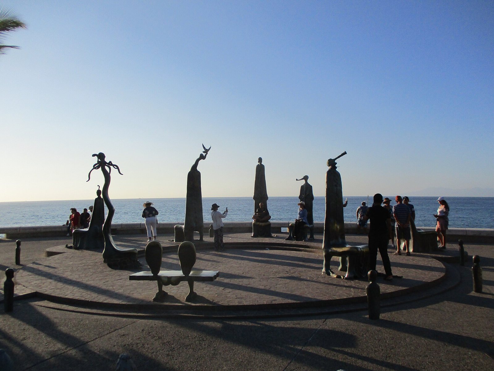 Sillas y figuras de bronce de La Rotonda del Mar en el Malecón, con el mar al fondo