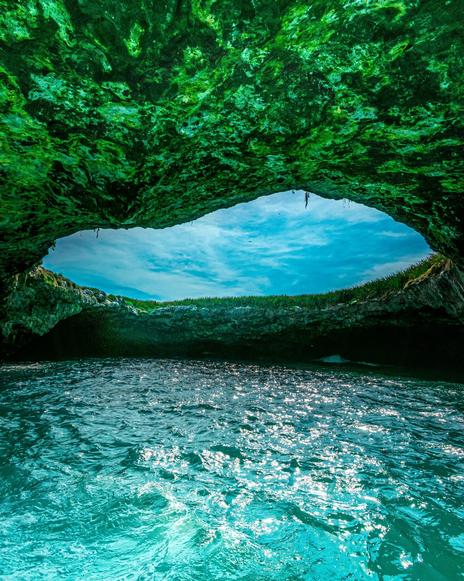 Vista desde el interior de la cueva de Playa Escondida en las Islas Marietas, con agua turquesa y el cielo al fondo