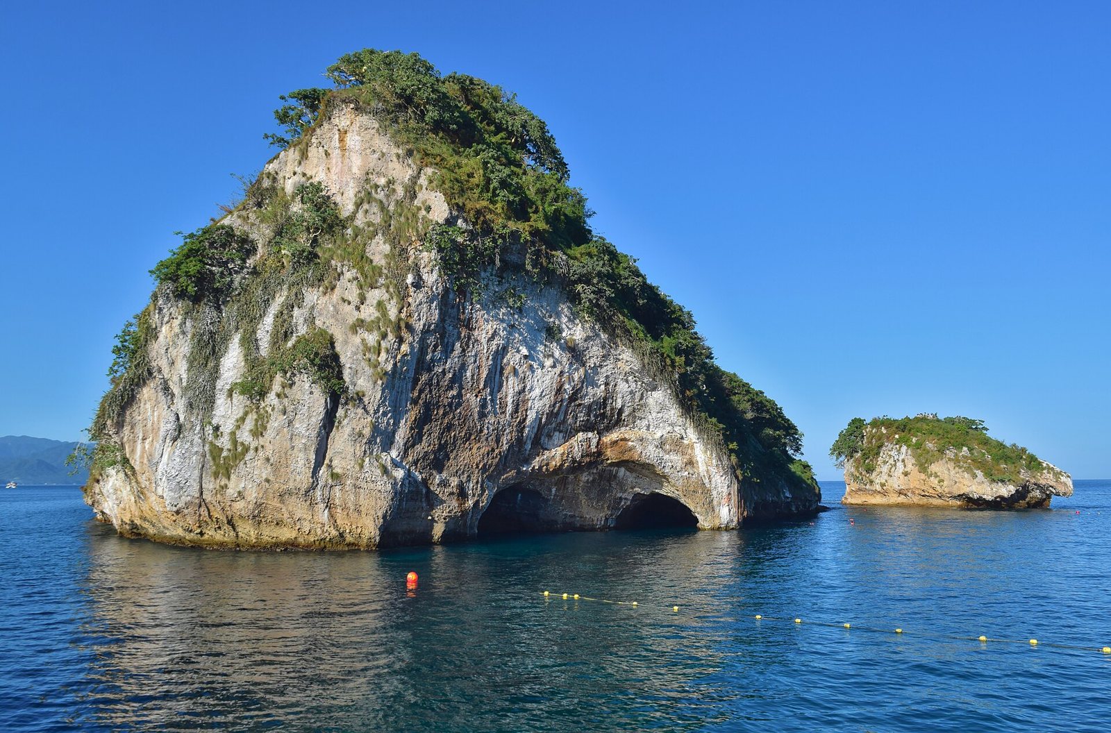 Islote de granito con un túnel natural en la base y otro islote más pequeño, en Los Arcos de Mismaloya