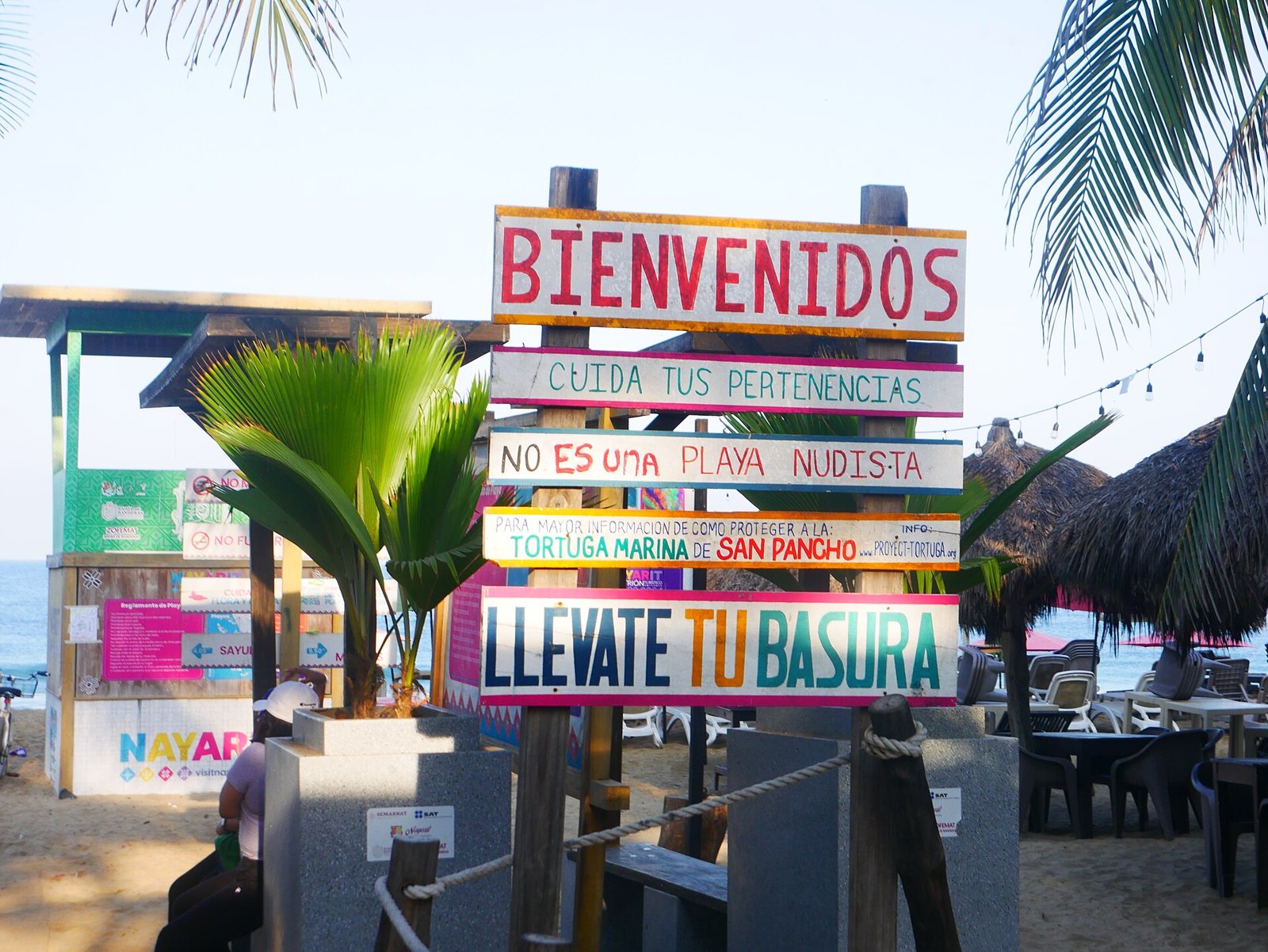 Letrero de madera de bienvenida a la playa de San Pancho con avisos para cuidar tus pertenencias, proteger a la tortuga marina y llevarte tu basura